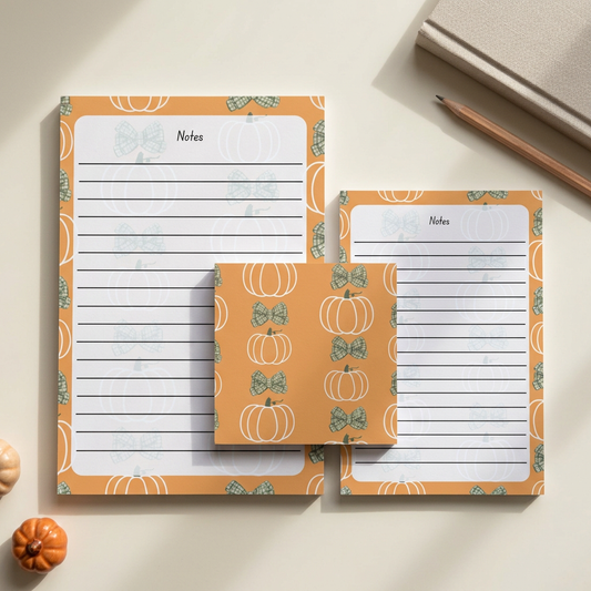 Pumpkins and green bows stationery in an autumn workspace flat lay