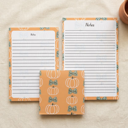 Pumpkins and green bows stationery styled on cream linen