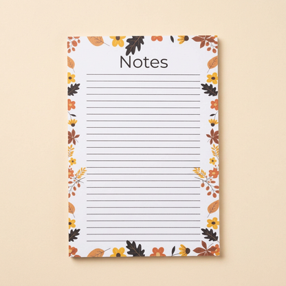 Leaves and acorns lined notepad on a soft cream background