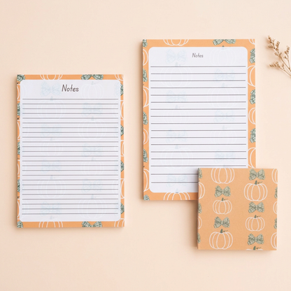 Pumpkins and green bows stationery on a light peach background